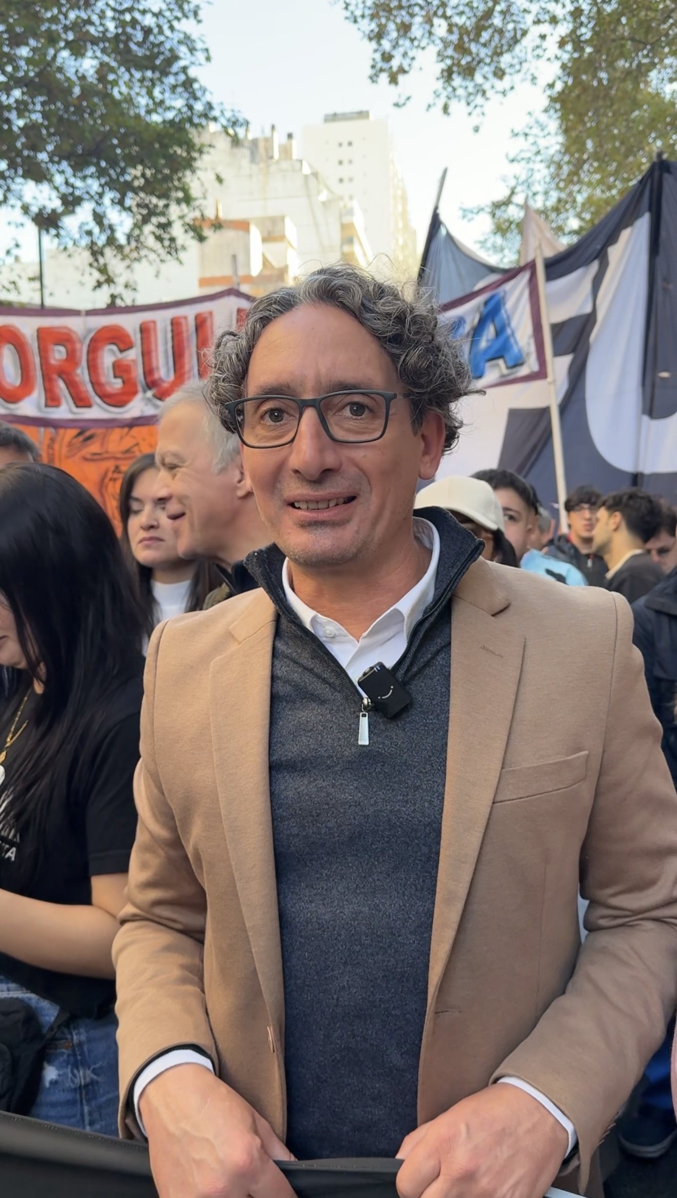 Emiliano Cagnacci, de frente, sostiene una bandera en una movilización universitaria.